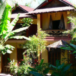Das Haus ist von tropischen Pflanzen und Bäumen umgeben.